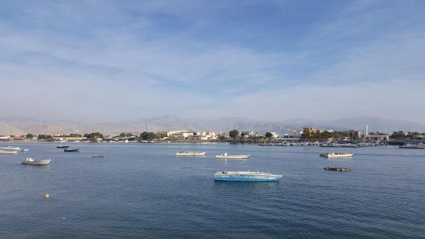 Ras Al Khaimah Bay com mar azul e céu nublado.
