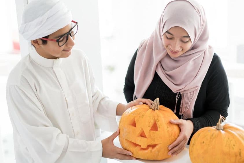 Criança árabe com uma abóbora de Halloween.