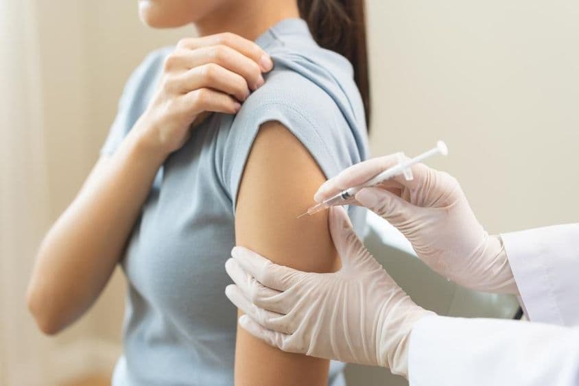 Um médico administrando uma vacina a um paciente em uma clínica.