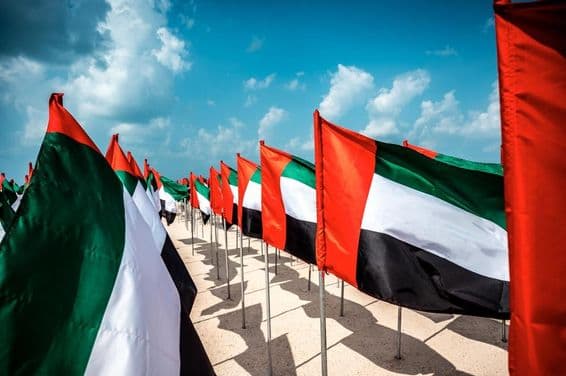 Bandeiras dos Emirados Árabes Unidos tremulando ao vento em uma praia popular de Dubai.