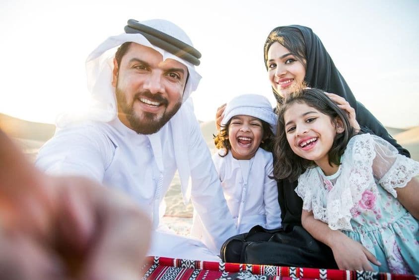Família feliz desfrutando de um dia maravilhoso no deserto fazendo um piquenique.