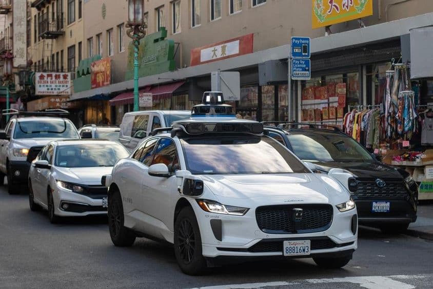 Robotáxi Waymo navegando pelas movimentadas e estreitas ruas de Chinatown em São Francisco.