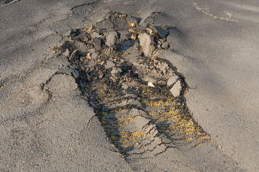 A superfície do asfalto da rua foi removida devido a má execução.