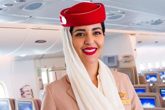 Comissária de bordo sorridente, companhia aérea Emirates.