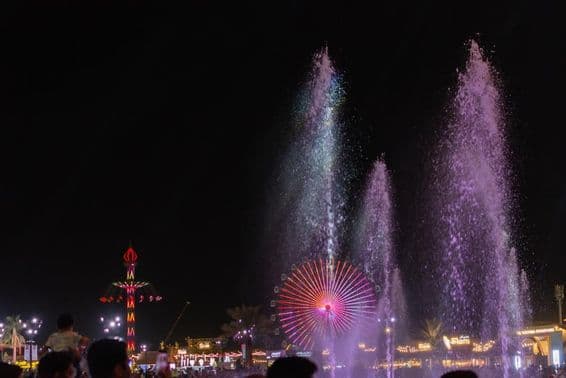 A cena noturna vibrante no Festival Sheikh Zayed com fontes de água.