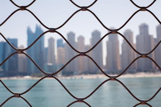 Vista dos arranha-céus em Dubai através das barras de ferro.