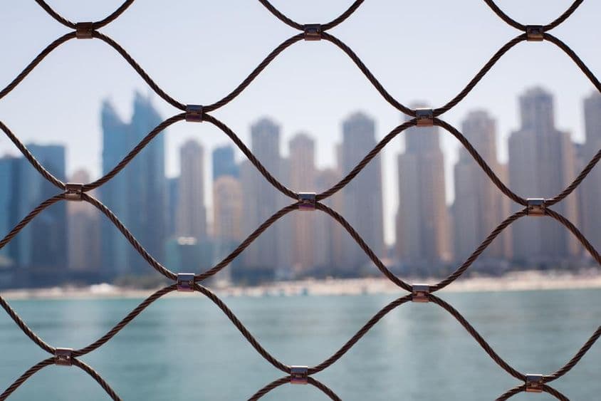 Vista dos arranha-céus em Dubai através das barras de ferro.
