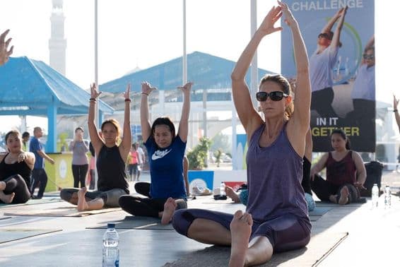 Mulheres praticando aeróbica e yoga durante o Desafio Fitness de Dubai 2025.