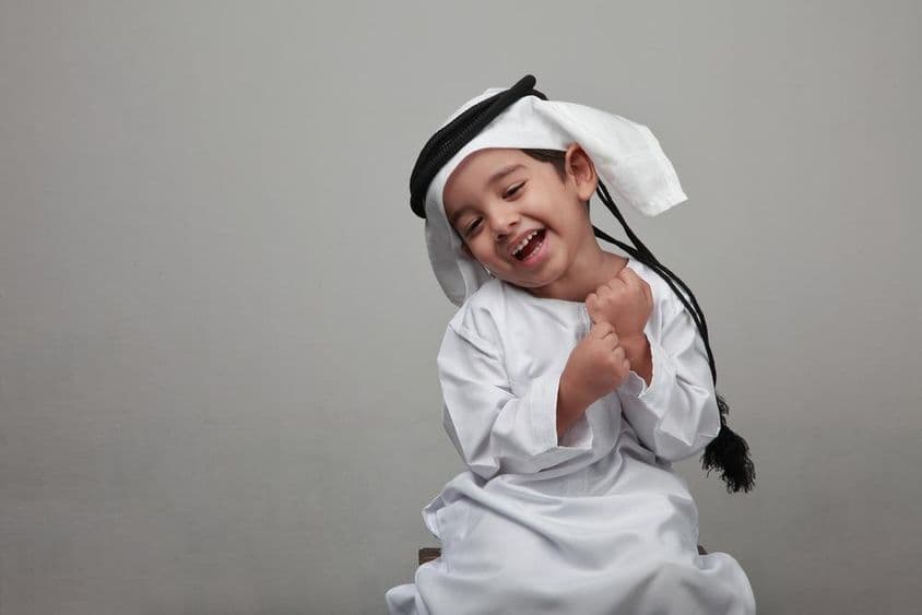 Menino jovem em traje árabe tradicional.