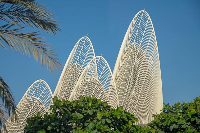 As torres aladas do Museu Nacional Zayed sob um céu azul claro.
