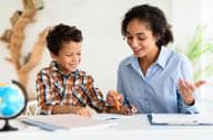 Professora jovem explicando uma lição a um menino.