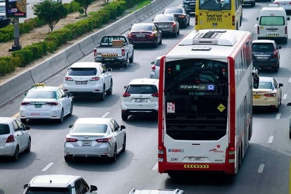 Rota de ônibus de dois andares e tráfego diurno nas ruas da cidade de Dubai.