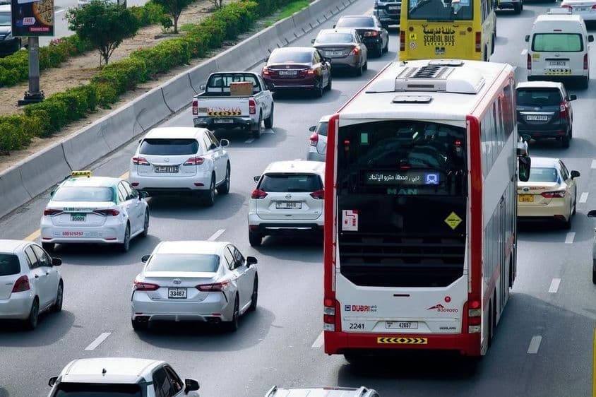 Rota de ônibus de dois andares e tráfego diurno nas ruas da cidade de Dubai.