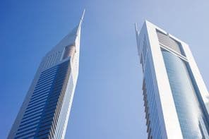 Dois arranha-céus sob um céu azul.