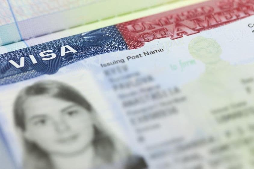 Visto dos EUA em uma página de passaporte (EUA) ao fundo.