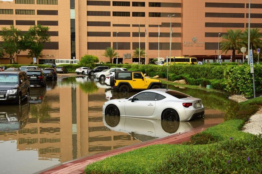 Veículos em um estacionamento encharcado de chuva em Dubai.