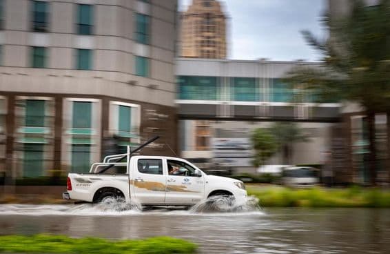 Carro dirigindo através de rua inundada em Dubai.