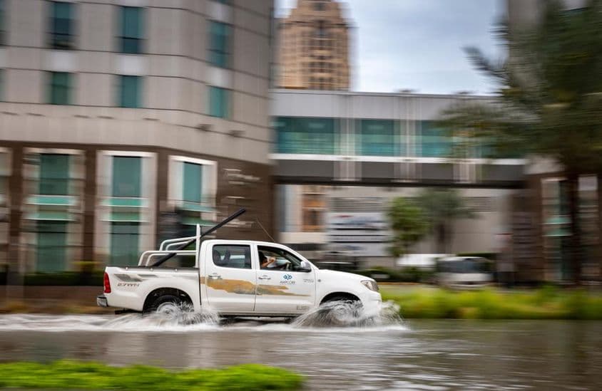 Carro dirigindo através de rua inundada em Dubai.
