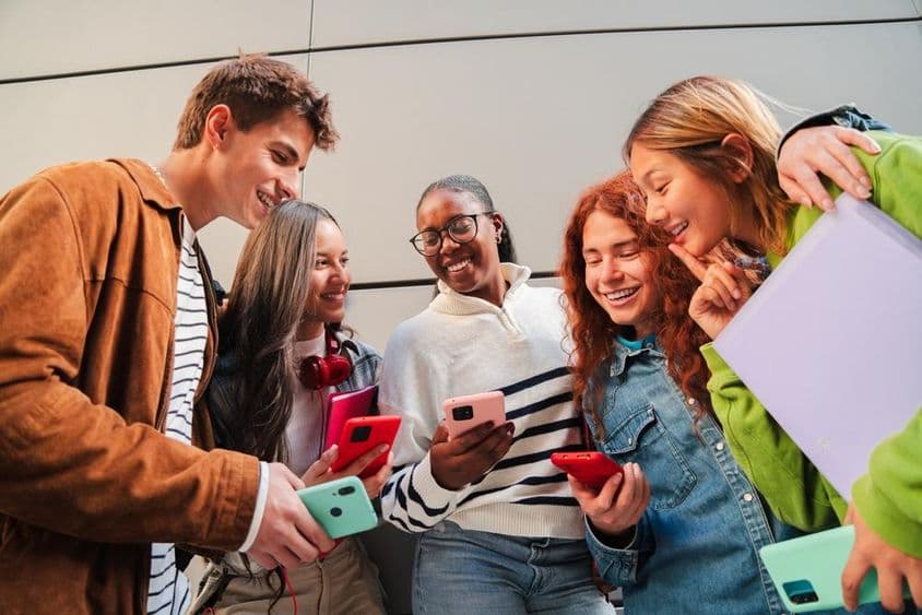 Estudantes usando telefones durante um intervalo.