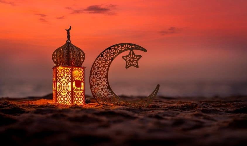 Lanterna tradicional com lua crescente na praia.