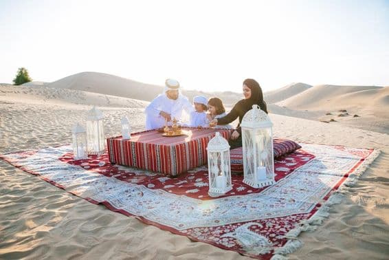 Família feliz desfrutando de um dia maravilhoso fazendo piquenique no deserto.