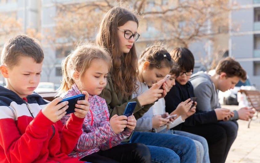 Crianças se comunicando via mensagens em um smartphone.