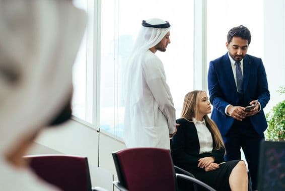 Equipe empresarial multinacional trabalhando junta em um escritório em Dubai.