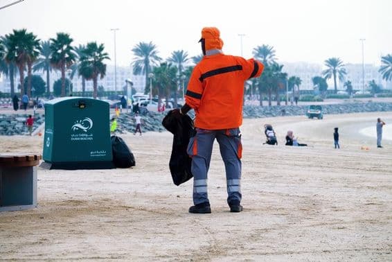 Dubai, Emirados Árabes Unidos, trabalhador limpando a praia.
