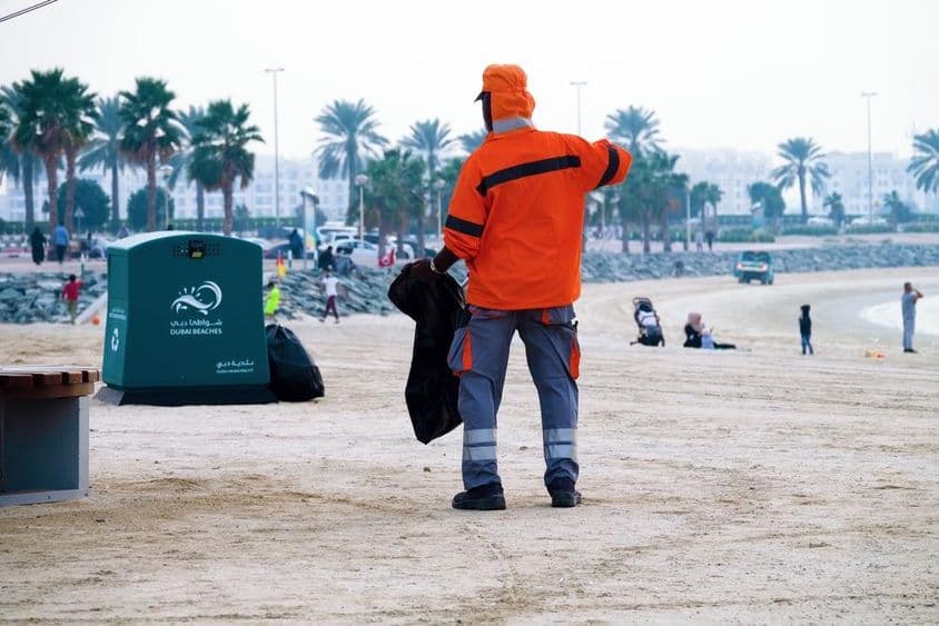 Dubai, Emirados Árabes Unidos, trabalhador limpando a praia.