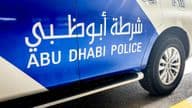 Carro da polícia de Abu Dhabi com letreiros em inglês e árabe.