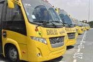 Vários ônibus escolares amarelos alinhados em um estacionamento em Dubai.