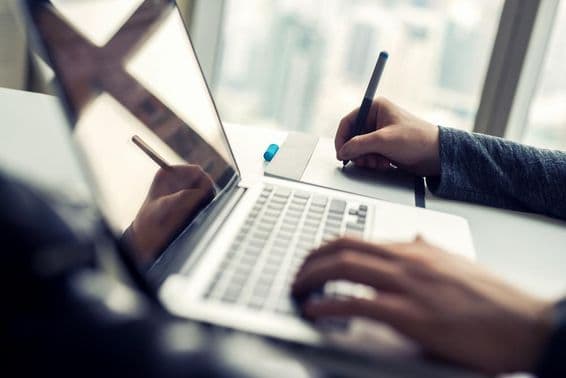 Fechamento em um homem trabalhando em um laptop.