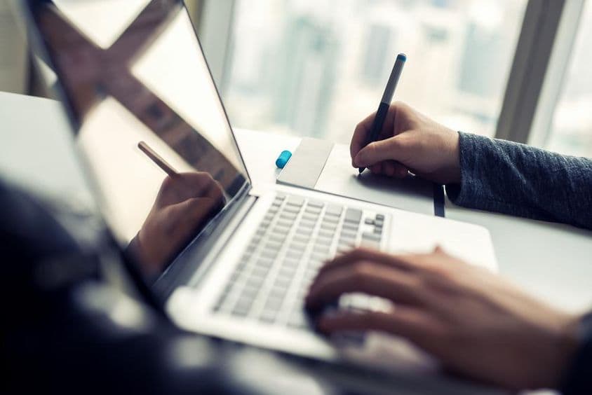 Fechamento em um homem trabalhando em um laptop.