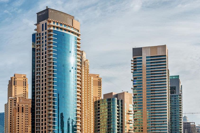 Prédios residenciais e hotéis em arranha-céus em torno do Dubai Marina.