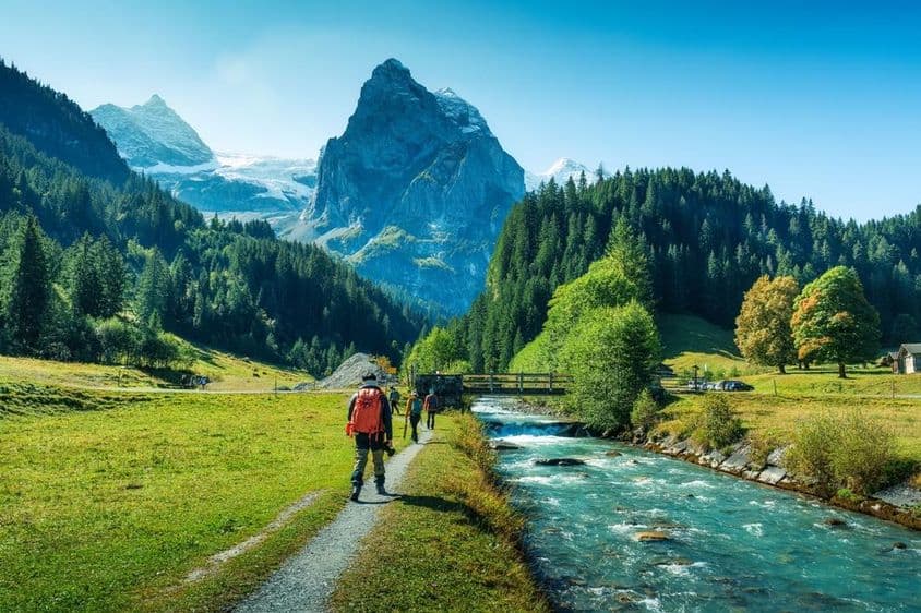 Grupo de turistas caminhando ao longo de um rio em uma floresta no cantão de Berna, Suíça.