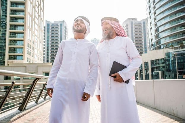 Dois empresários em trajes tradicionais Emirati se reunindo em Dubai.