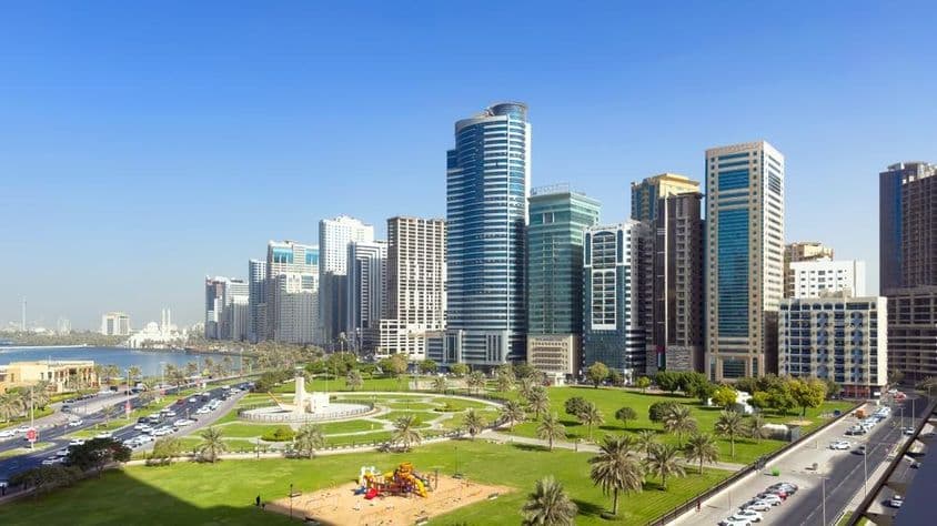 Amplo gramado e vista serena da lagoa no Al Majaz Waterfront.