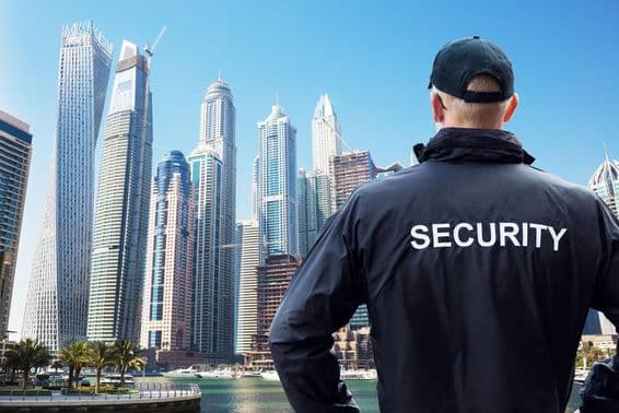 Guardião de segurança masculino observando o horizonte da cidade por trás.