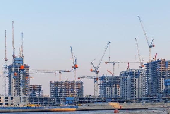 Construção imobiliária no Dubai Creek Harbor, guindastes, torres inacabadas.