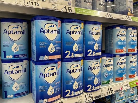 Leite em pó Aptamil nas prateleiras de supermercado.