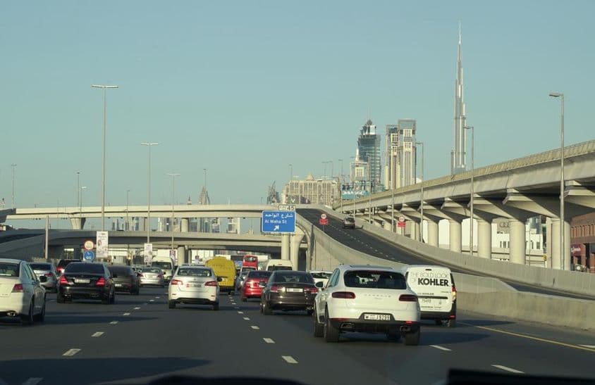 Congestionamento de tráfego durante o horário de pico em Dubai com os famosos arranha-céus de Dubai ao fundo.