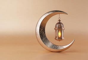 Crescente decorativo com uma lâmpada de Ramadã brilhante.