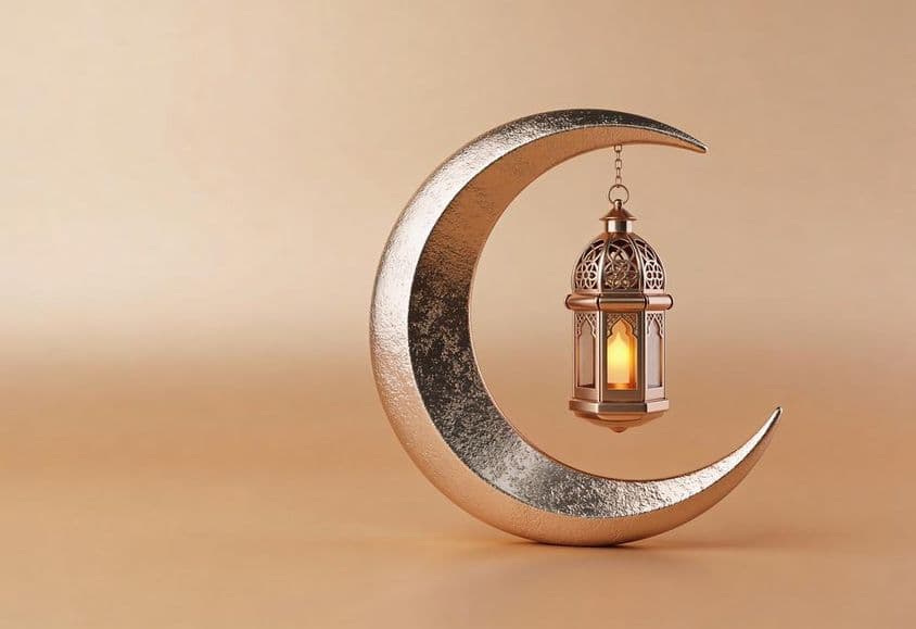 Crescente decorativo com uma lâmpada de Ramadã brilhante.