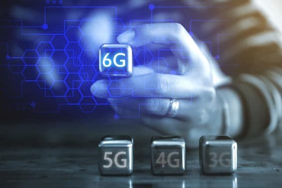 Um jovem empresário usando uma esfera de aço em forma de cubo, vendo a legenda: 6G.