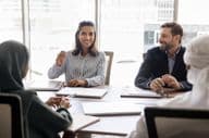 mulher de negócios conversando com parceiros árabes.