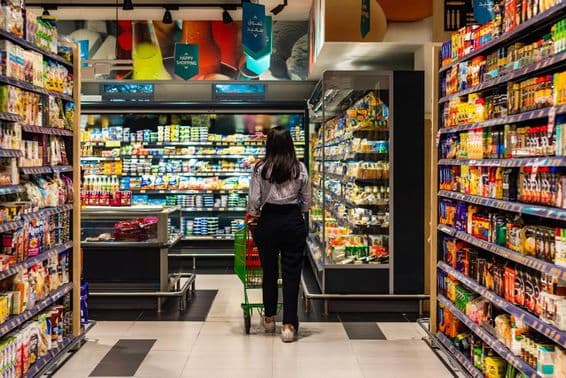 Uma jovem mulher comprando no supermercado Lulu.
