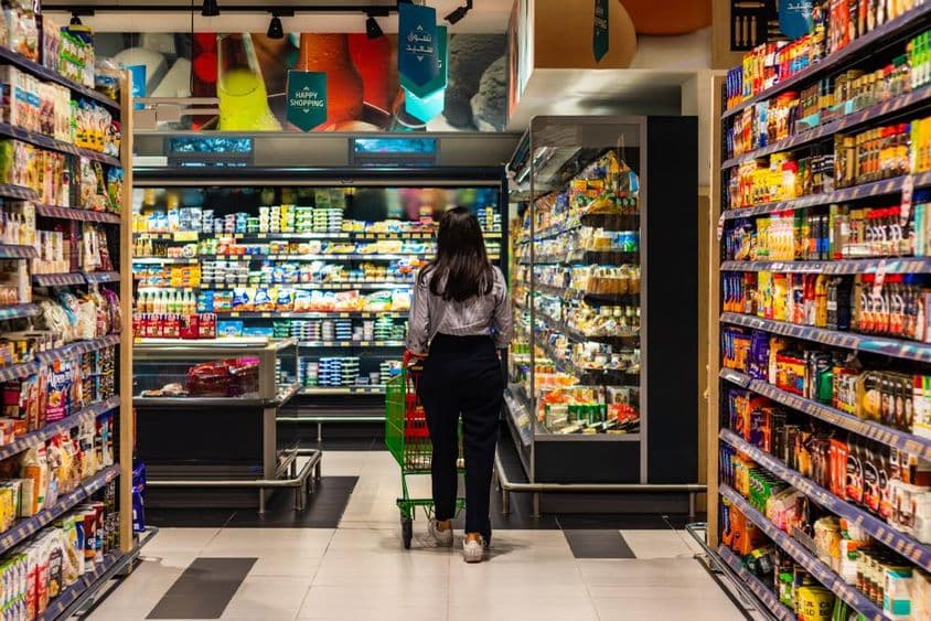 Uma jovem mulher comprando no supermercado Lulu.