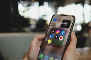 Tela do iPhone 15 Pro com ícones de aplicativos de redes sociais.