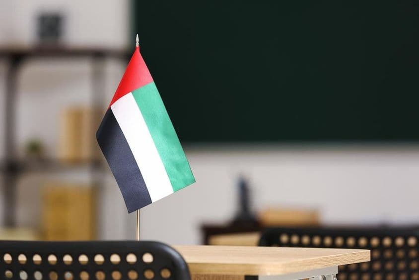 A bandeira dos Emirados Árabes Unidos sobre uma mesa na sala de aula