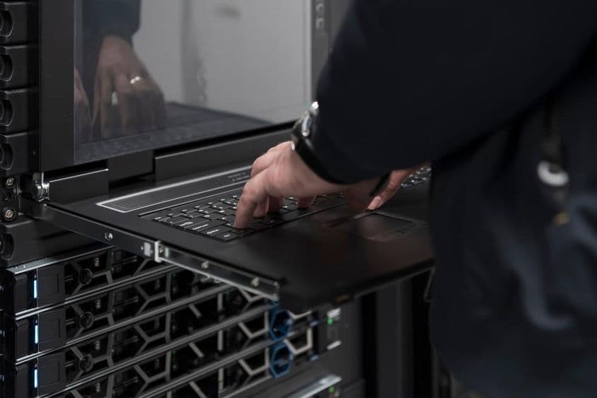 Um engenheiro usando um supercomputador em uma sala de servidores.